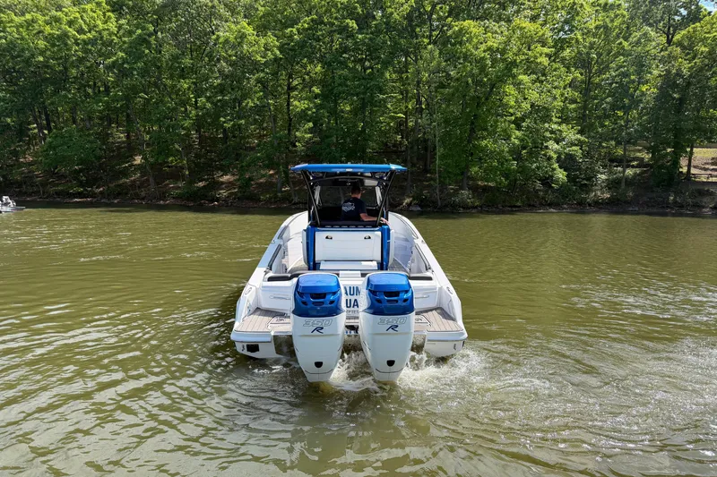 Slide: The Image of 2020 Nor-Tech 340 Sport Center Console boat cruising on a lake with forested shoreline. - 4
