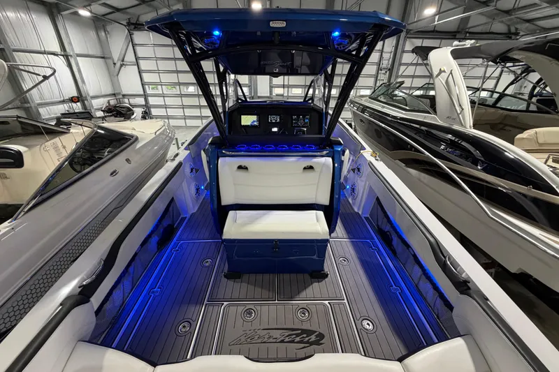 Slide: The Image of 2020 Nor-Tech 340 Sport Center Console boat with illuminated interior in a showroom. - 40
