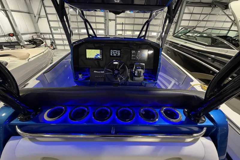 Slide: The Image of 2020 Nor-Tech 340 Sport Center Console with illuminated dashboard and cup holders in a garage. - 41
