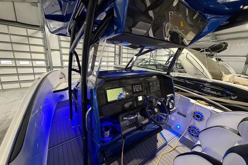 Slide: The Image of 2020 Nor-Tech 340 Sport Center Console boat interior with advanced navigation system and blue LED lighting. - 43