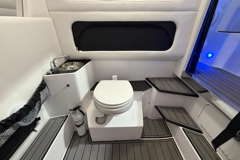 Slide: The Image of Interior of 2020 Nor-Tech 340 Sport Center Console, featuring a compact marine toilet. - 48