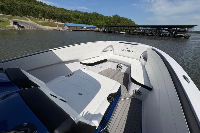 Slide: The Image of 2020 Nor-Tech 340 Sport Center Console boat with spacious seating on a calm lake. - 9