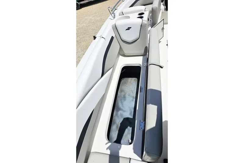 Slide: The Image of 2023 Starcraft SVX 211 OB boat interior with open storage compartment and cushioned seating. - 16