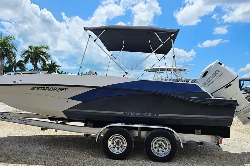 Slide: The Image of 2023 Starcraft SVX 211 OB boat on trailer, featuring Suzuki outboard motor. - 2