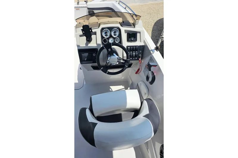 Slide: The Image of 2023 Starcraft SVX 211 OB boat cockpit with steering wheel and control panel. - 3