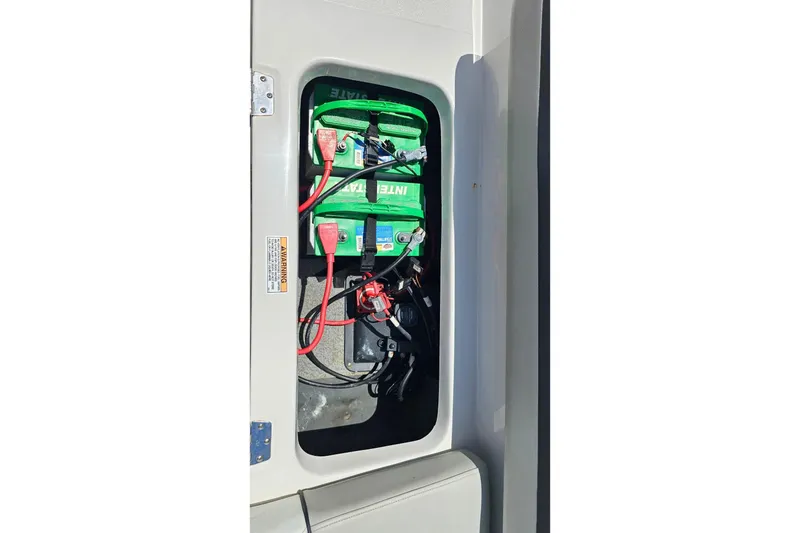 Slide: The Image of Battery compartment of 2023 Starcraft SVX 211 OB boat, featuring green batteries and wiring. - 4