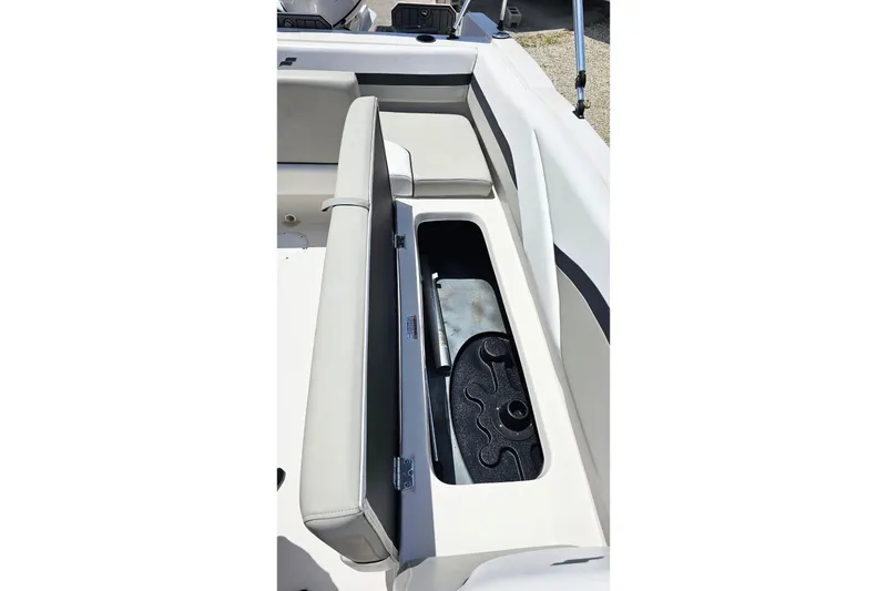 Slide: The Image of 2023 Starcraft SVX 211 OB boat with open storage compartment and cushioned seating. - 9