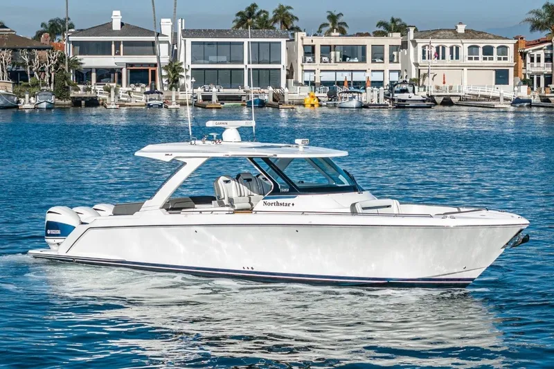 The Image of 2019 Tiara Yachts 38 LS on calm water with modern homes in background. - 0