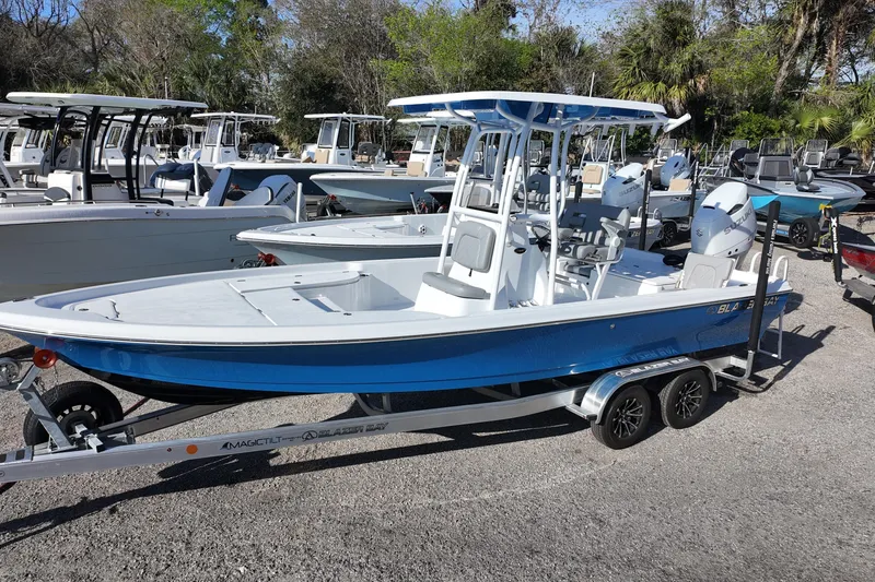 The Image of 2026 Blazer PureBay 2400 boat on trailer, parked among other boats. - 0