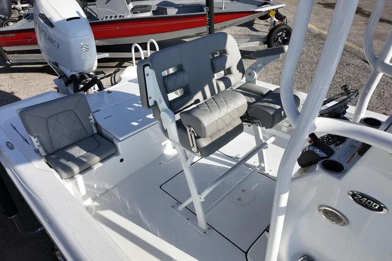 Slide: The Image of 2026 Blazer PureBay 2400 boat interior with cushioned seating and Suzuki outboard motor. - 11