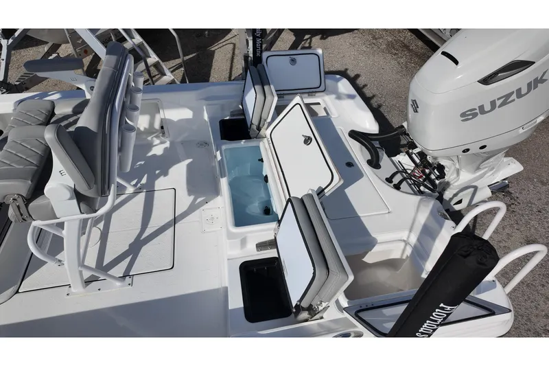 Slide: The Image of 2026 Blazer PureBay 2400 boat with Suzuki engine, featuring open storage compartments. - 13