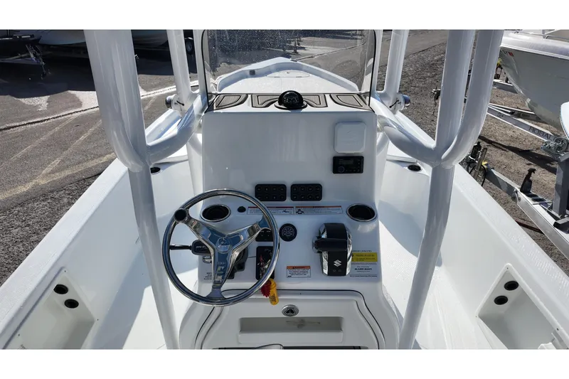 Slide: The Image of 2026 Blazer PureBay 2400 boat console with steering wheel and controls, docked outdoors. - 6