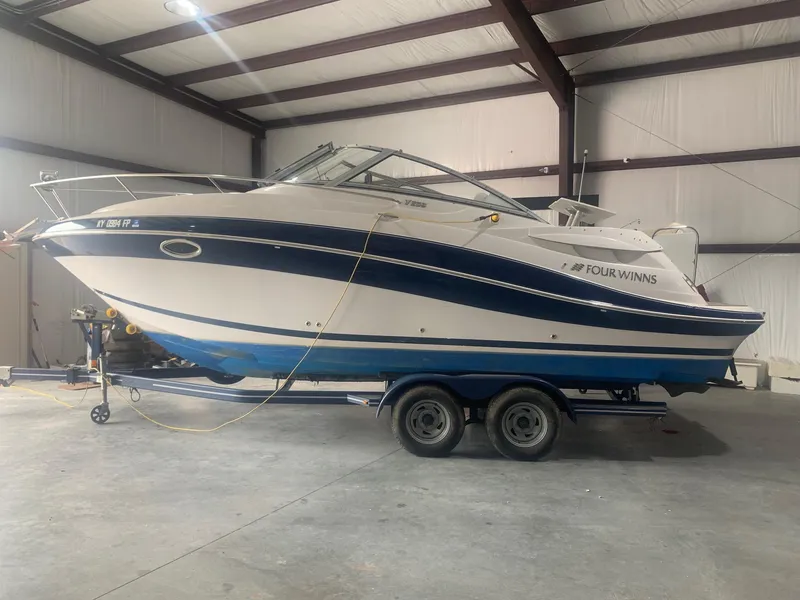 The Image of 2008 Four Winns V258 boat on trailer in indoor storage facility. - 0