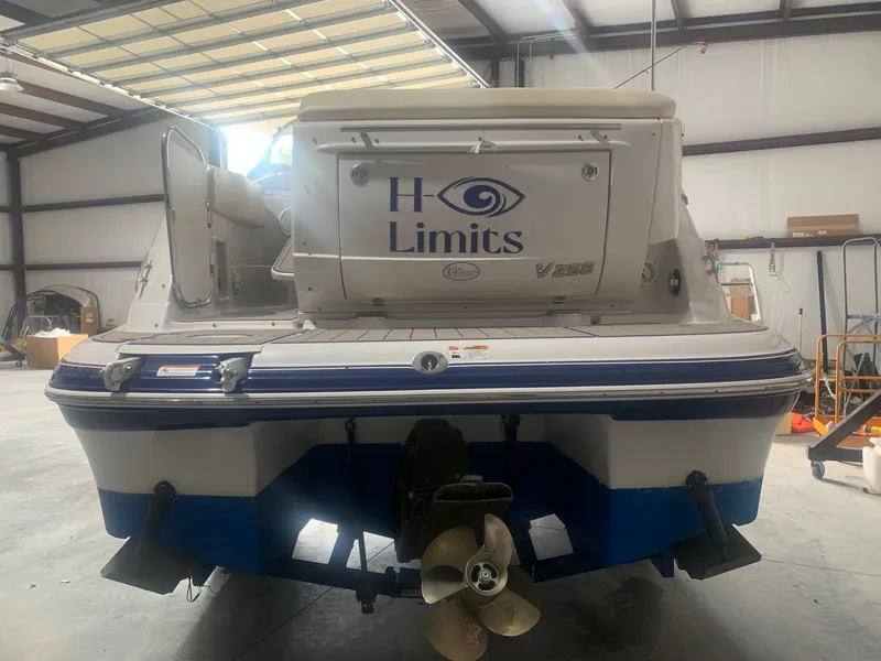 Slide: The Image of 2008 Four Winns V258 boat in a warehouse, rear view with "H Limits" branding. - 14