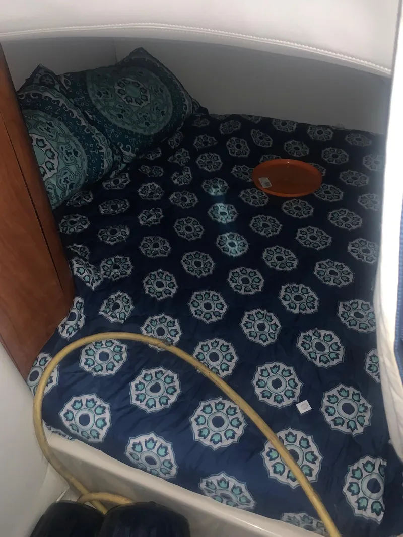 Slide: The Image of 2008 Four Winns V258 cabin interior with patterned bedding and decorative pillows. - 32