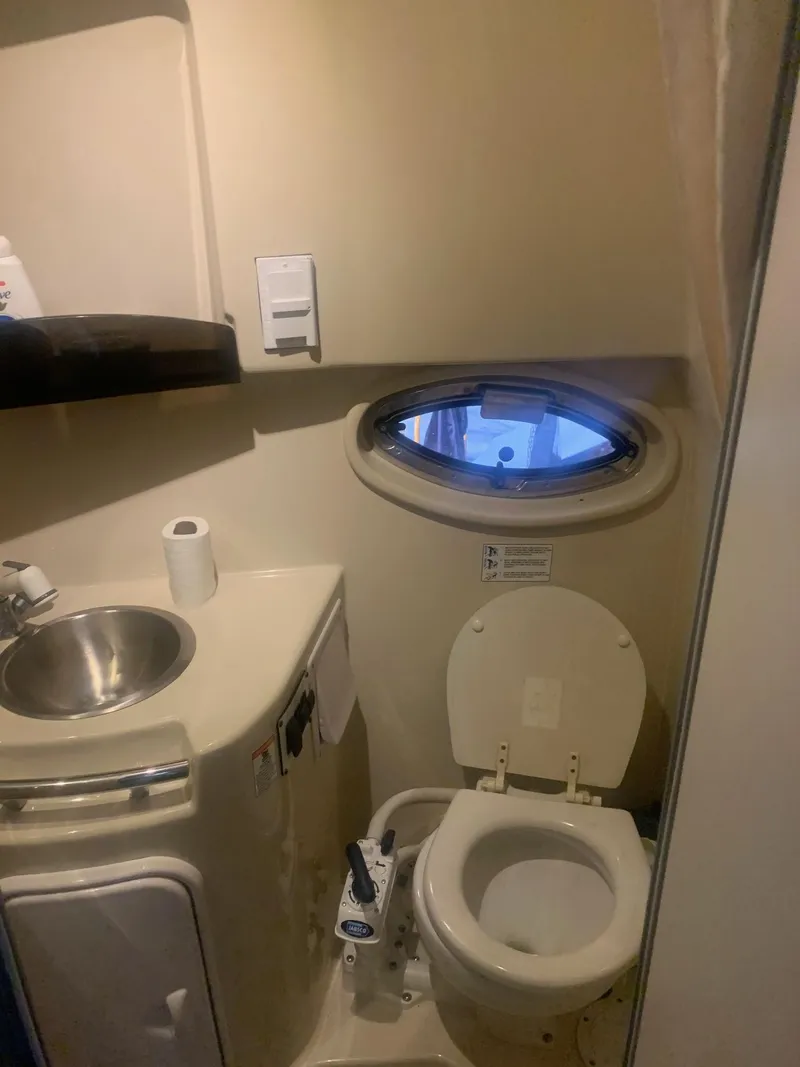 Slide: The Image of 2008 Four Winns V258 boat bathroom with sink, toilet, and porthole window. - 34