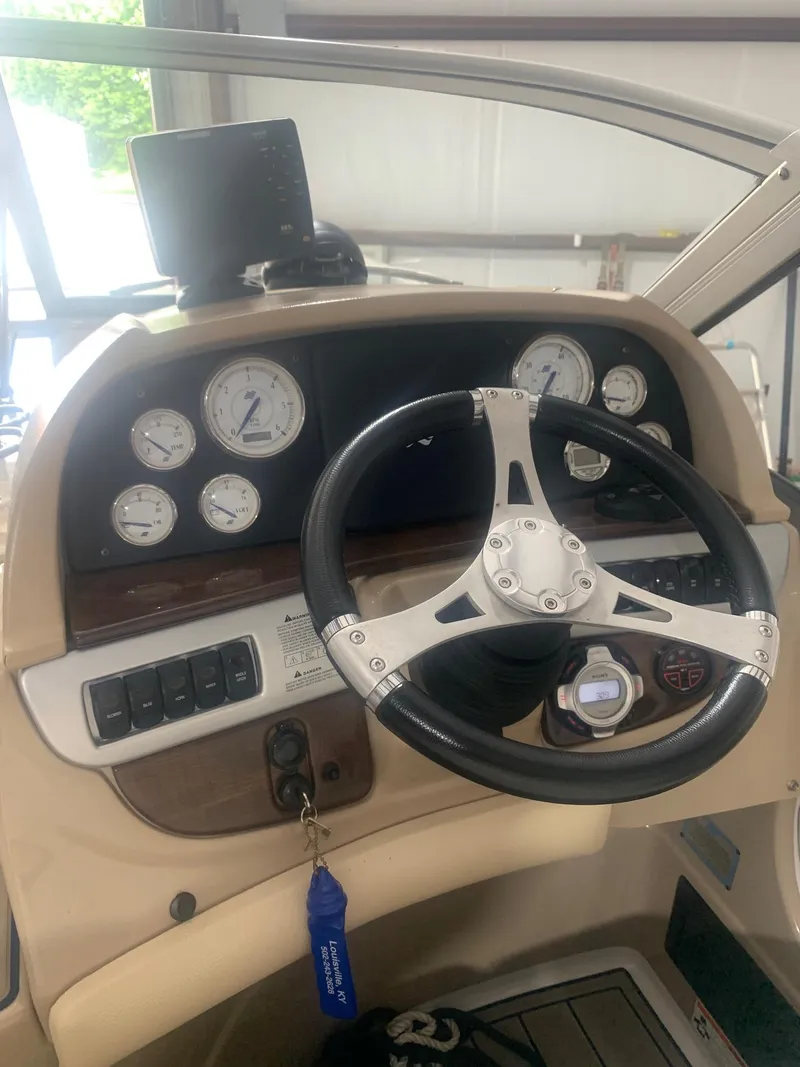 Slide: The Image of 2008 Four Winns V258 boat dashboard with steering wheel and gauges. - 35