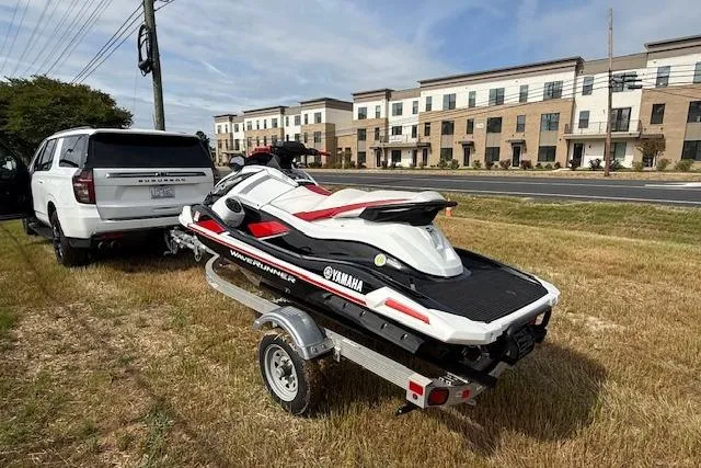 Slide: The Image of 2021 Yamaha WaveRunner VX Deluxe on trailer, parked near modern buildings. - 5