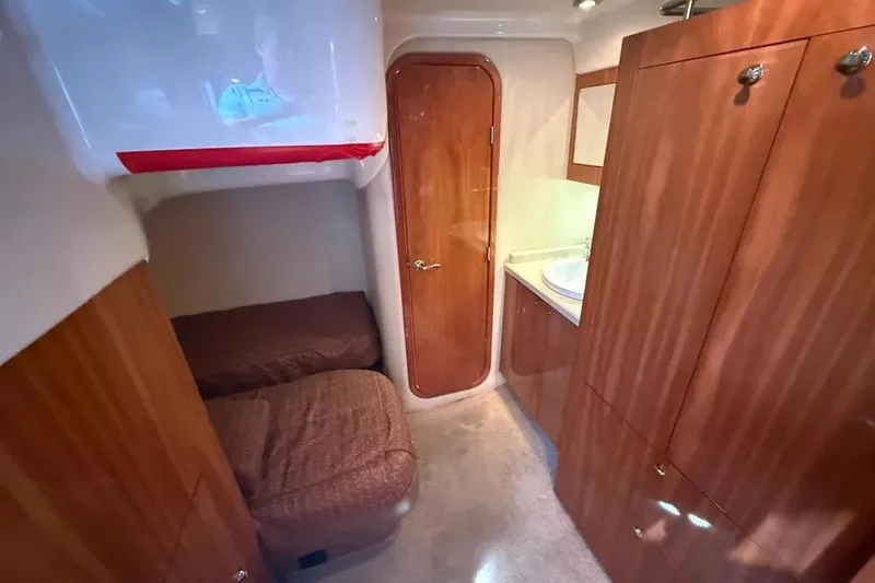 Slide: The Image of Interior cabin of 2011 Regal 46 Sport Coupe with wood finish and twin beds. - 12