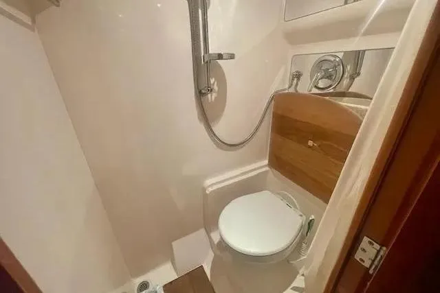 Slide: The Image of Bathroom interior of 2011 Regal 46 Sport Coupe yacht, featuring compact shower and toilet. - 13