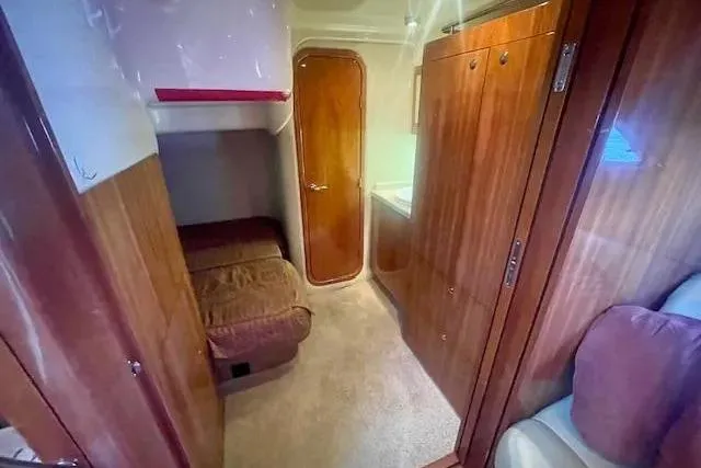 Slide: The Image of Interior cabin of 2011 Regal 46 Sport Coupe with wooden finishes and cozy seating. - 15