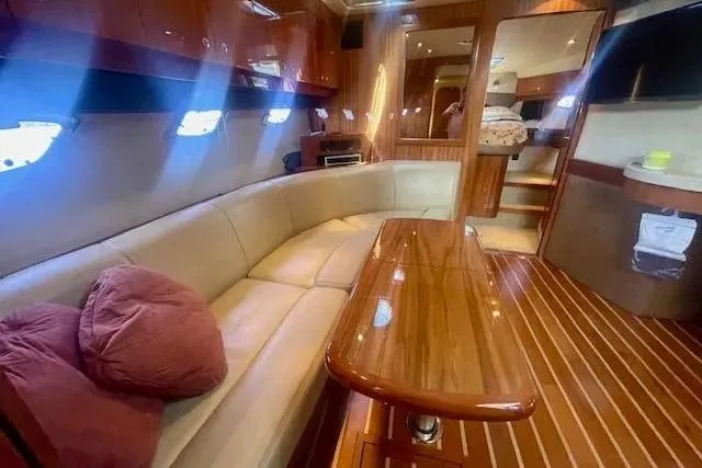 Slide: The Image of Luxurious interior of a 2011 Regal 46 Sport Coupe yacht with plush seating and wooden finishes. - 18