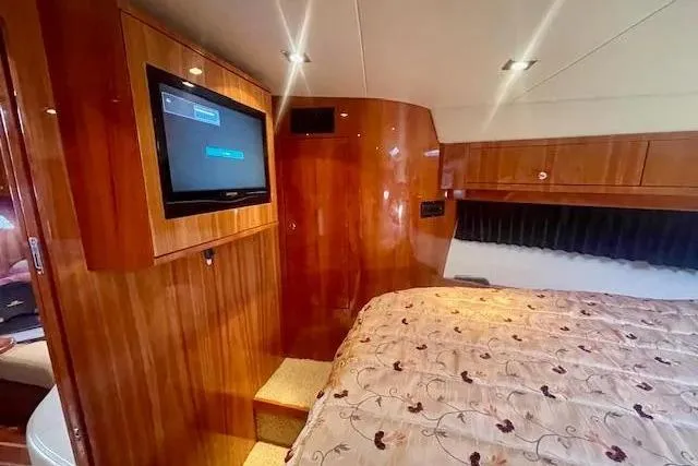 Slide: The Image of Luxurious cabin interior of 2011 Regal 46 Sport Coupe with wood paneling and TV. - 24