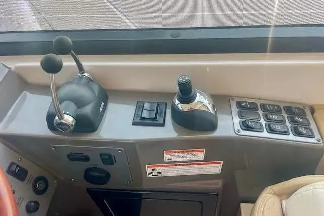 Slide: The Image of Control panel of a 2011 Regal 46 Sport Coupe boat, featuring levers and switches. - 26