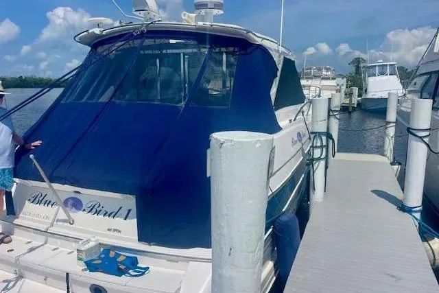 Slide: The Image of 2011 Regal 46 Sport Coupe docked at marina under clear blue sky. - 3