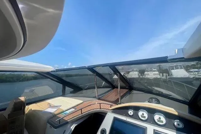Slide: The Image of Cockpit view of 2011 Regal 46 Sport Coupe yacht with clear skies and marina backdrop. - 31