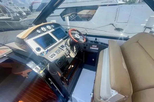 Slide: The Image of 2011 Regal 46 Sport Coupe cockpit with modern controls and tan seating. - 32