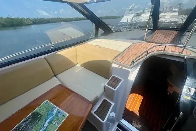 Slide: The Image of 2011 Regal 46 Sport Coupe interior with seating, table, and scenic water view. - 34