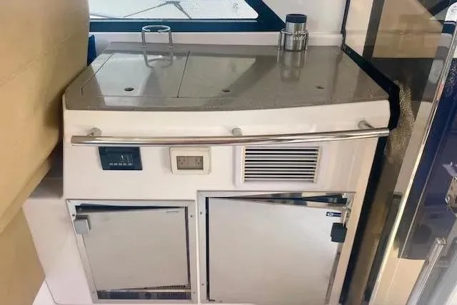 Slide: The Image of 2011 Regal 46 Sport Coupe yacht kitchenette with stainless steel appliances and countertop. - 36