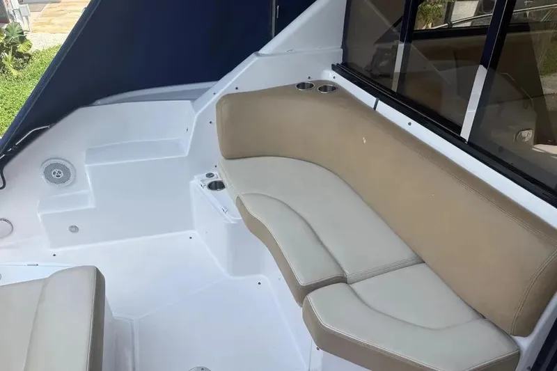 Slide: The Image of Interior seating of a 2011 Regal 46 Sport Coupe boat, featuring beige cushions and cup holders. - 6