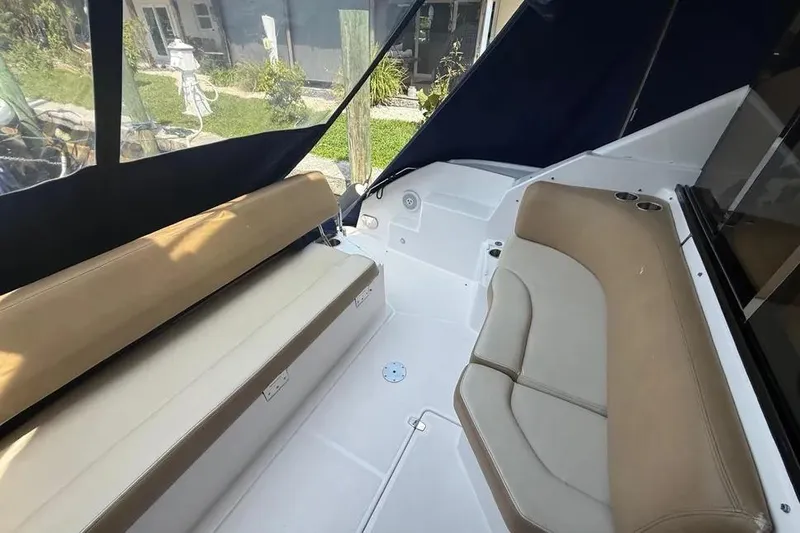 Slide: The Image of Interior seating of 2011 Regal 46 Sport Coupe yacht with beige cushions and cup holders. - 8