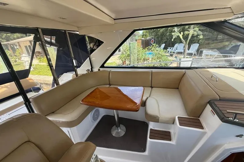 Slide: The Image of Interior of 2011 Regal 46 Sport Coupe with beige seating and wooden table. - 9