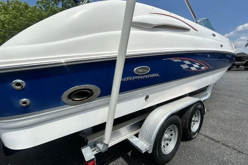 Slide: The Image of 2006 Chaparral Sunesta 274 boat on trailer, featuring sleek blue and white design. - 5