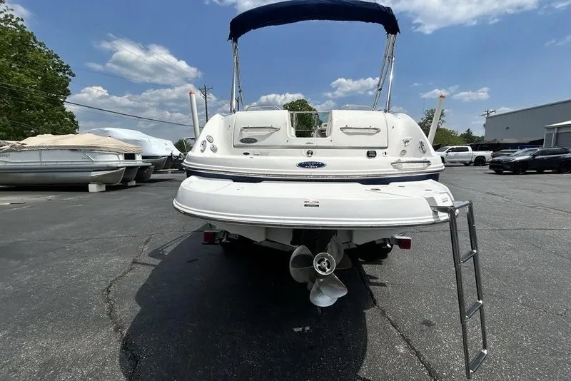 Slide: The Image of 2006 Chaparral Sunesta 274 boat, rear view, parked outdoors under a blue sky. - 6