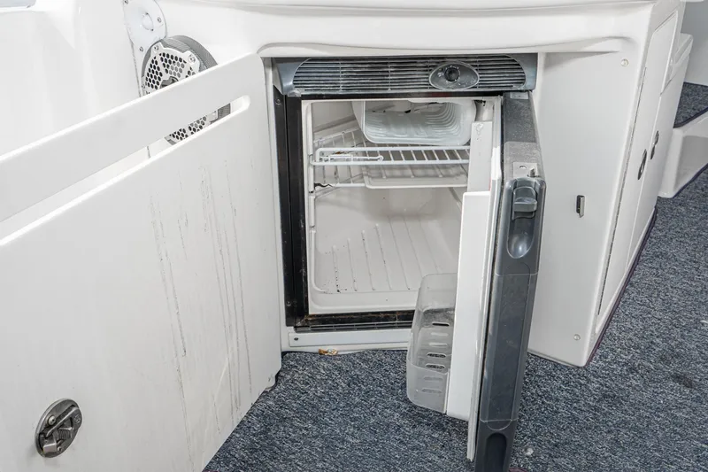 Slide: The Image of Open mini fridge on 2007 Sea Ray 340 Sundancer boat, showing interior shelves. - 21
