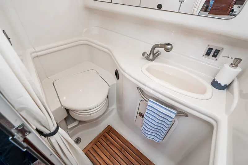 Slide: The Image of 2007 Sea Ray 340 Sundancer bathroom with toilet, sink, and wooden floor mat. - 49