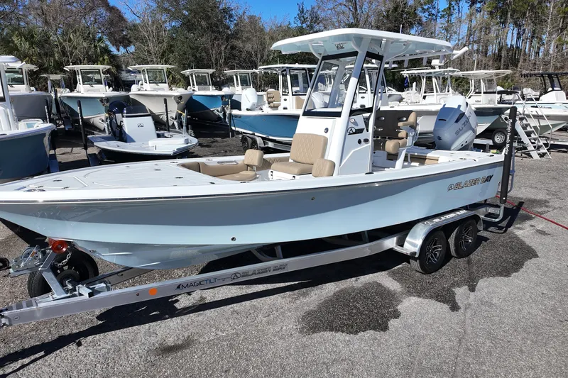 The Image of 2026 Blazer Bay 2440 boat on trailer, surrounded by other boats in a marina. - 0
