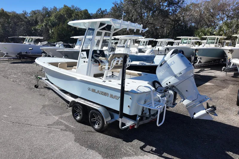 Slide: The Image of 2026 Blazer Bay 2440 boat with Suzuki outboard motor on trailer. - 2