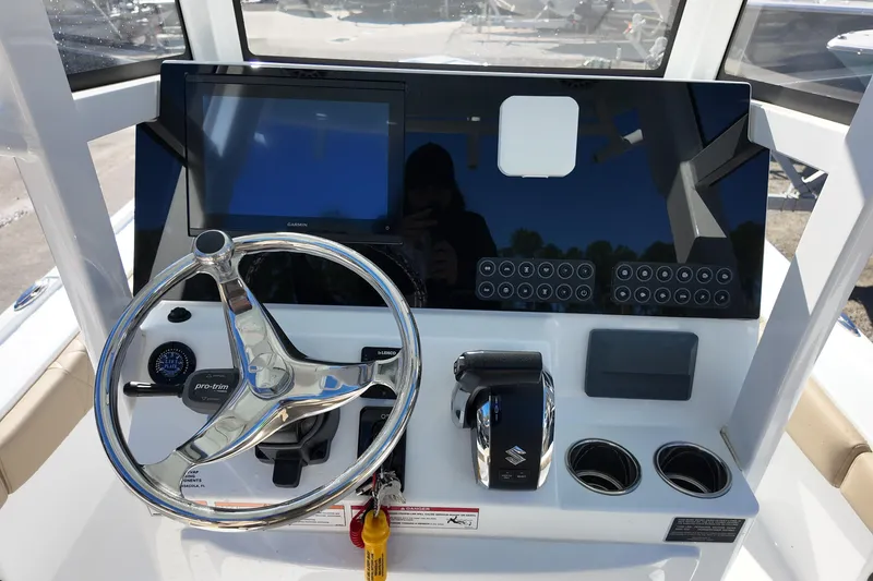 Slide: The Image of 2026 Blazer Bay 2440 boat dashboard with steering wheel, controls, and touchscreen display. - 5