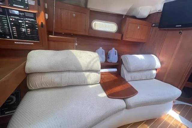 Slide: The Image of Interior of 2001 Hunter 380 yacht with cushioned seating and wooden cabinetry. - 11