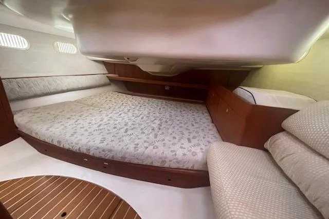 Slide: The Image of Interior cabin of a 2001 Hunter 380 sailboat with a spacious bed and wooden accents. - 14