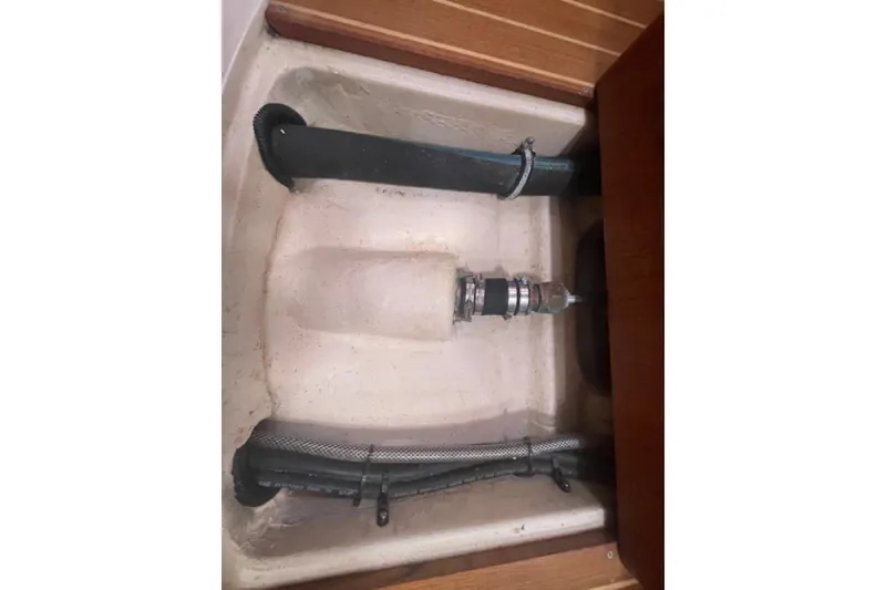 Slide: The Image of Bilge compartment of a 2001 Hunter 380 sailboat, featuring hoses and fittings. - 16