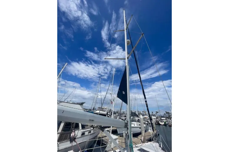 Slide: The Image of Sailboat mast of 2001 Hunter 380 against a vibrant blue sky at marina. - 26
