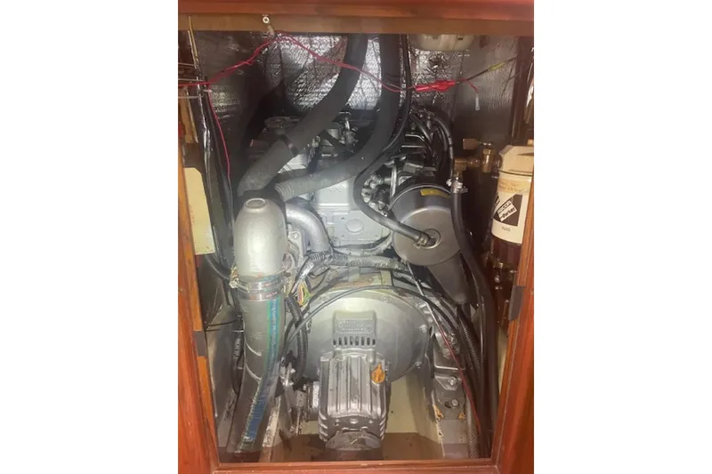 Slide: The Image of Engine compartment of a 2001 Hunter 380 sailboat, showcasing mechanical components and wiring. - 31