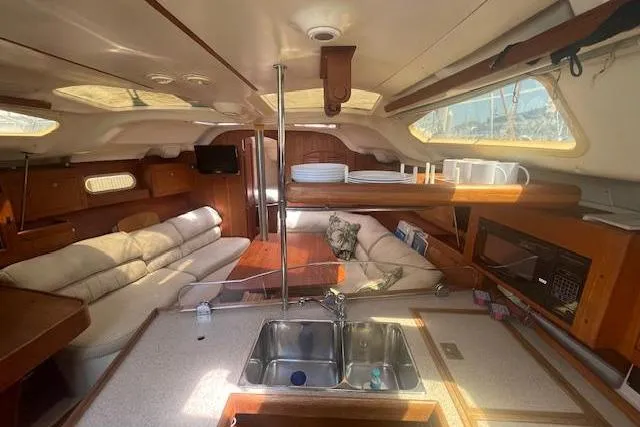 Slide: The Image of Interior of a 2001 Hunter 380 sailboat with cozy seating and kitchen area. - 9