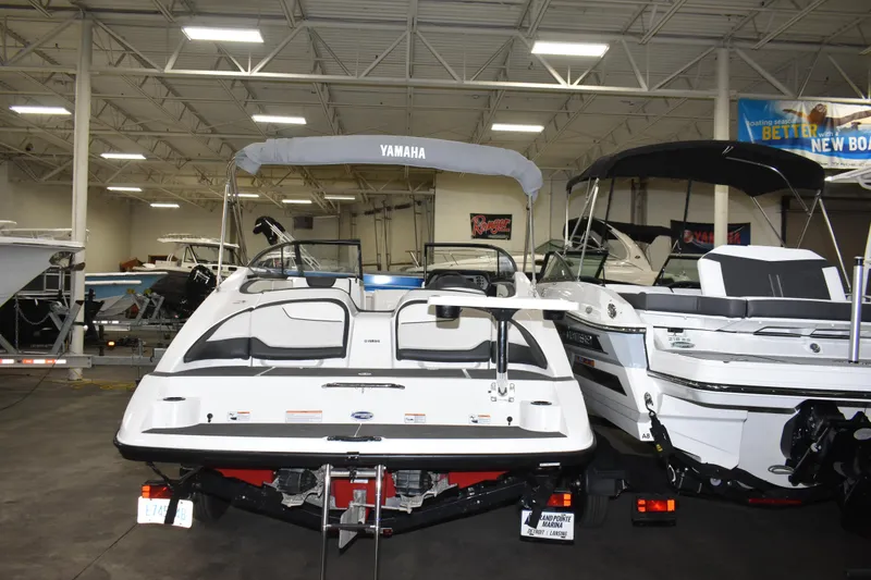 Slide: The Image of 2017 Yamaha SX210 boat displayed in a showroom, rear view with canopy. - 4